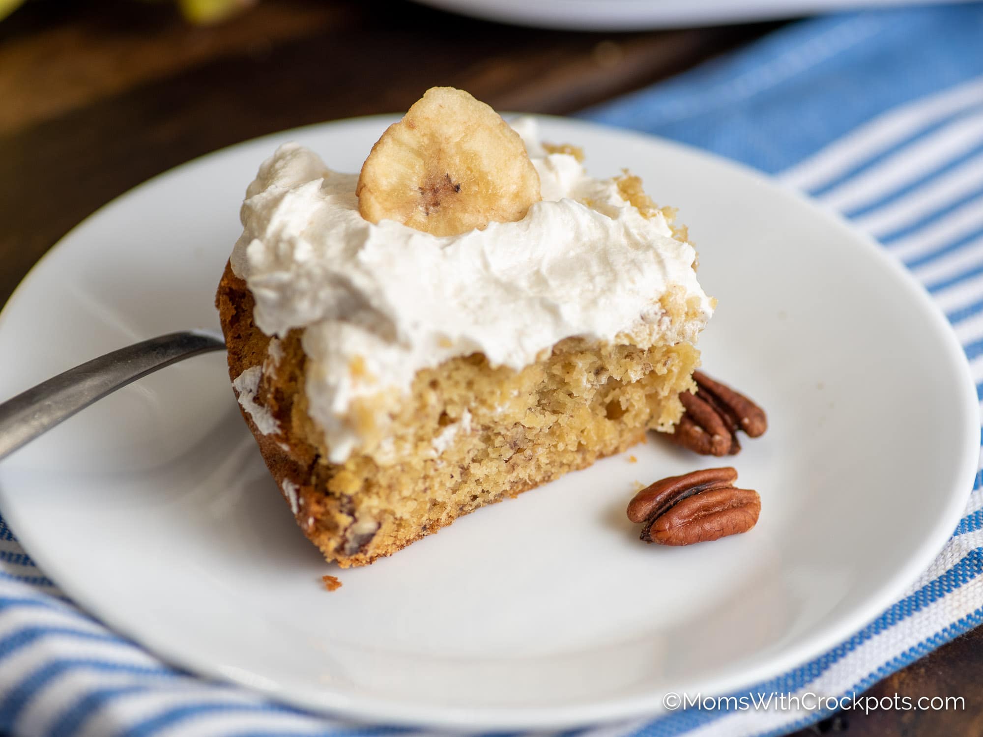 Crockpot Banana Cake on plate with pecans and banana chip